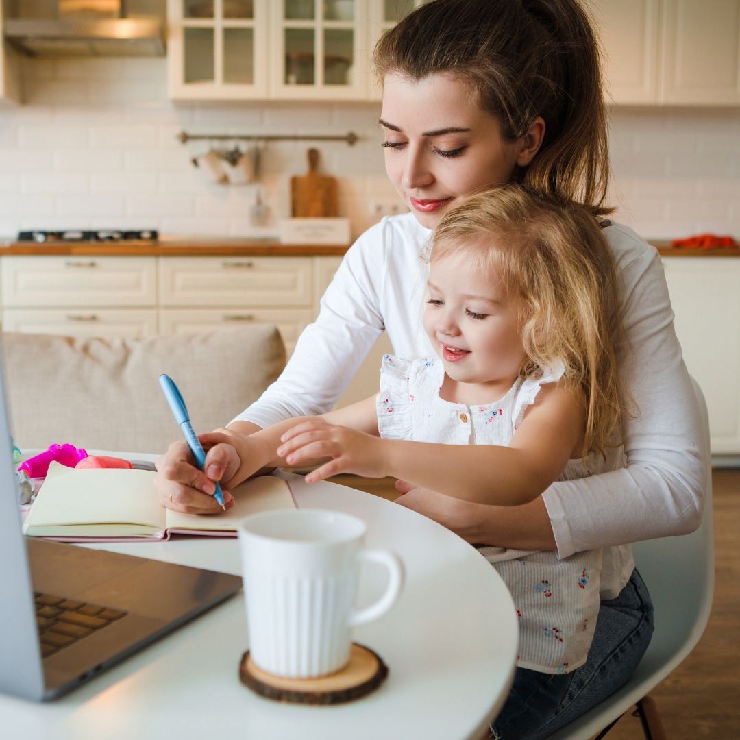 Moeder en dochter samen aan de keukentafel met laptop